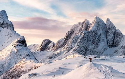 Mountain climber on top of snowy mountain range