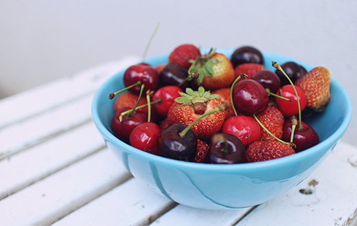 Strawberries and cherries on-blue-bowl