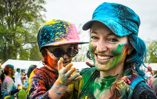Woman carrying child on color run