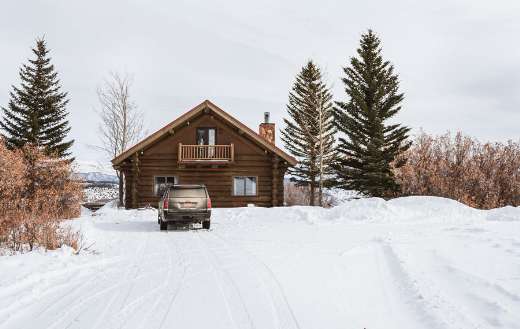 Brown wooden house on snow covered ground