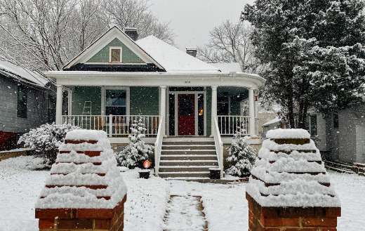 Snow covered wooden house near trees puzzle