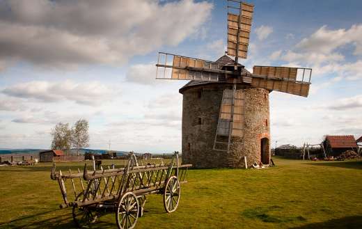 Wooden windmill near wooden carriage