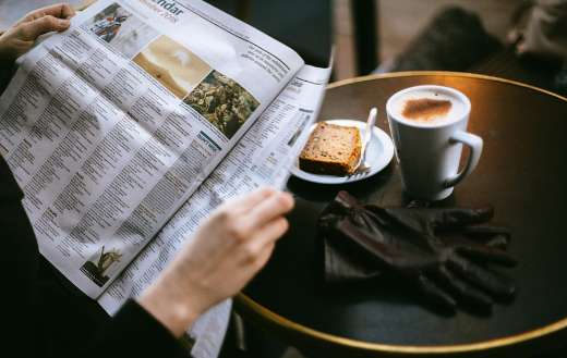 Photo of person reading with coffee bread