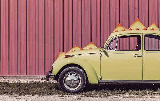 Yellow car beside red wall online