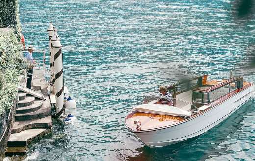 Motor boats on rippled sea against ridge and anonymous tourist