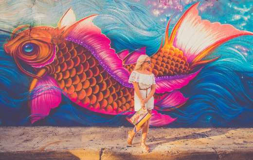 Woman standing near fish graphic wall