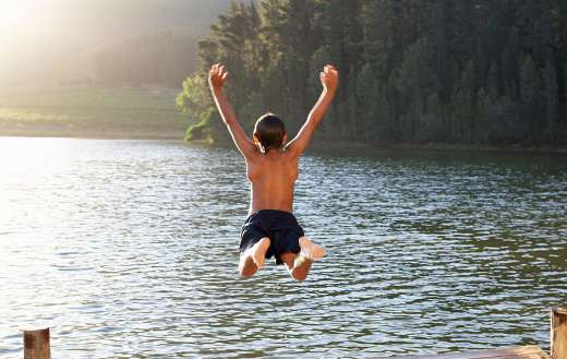 Young boy jumping into lake puzzle
