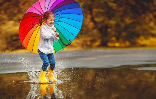 Happy funny child with multicolored umbrella