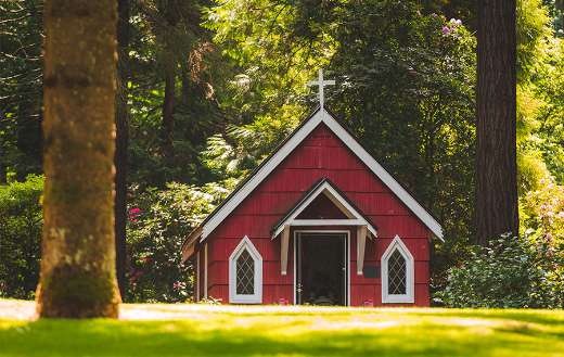 Red chapel on grassy field