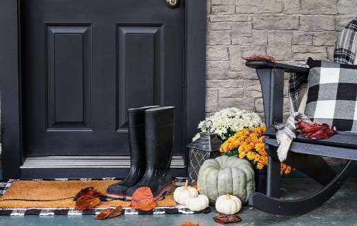 Front porch decorated for autumn with buffalo plaid