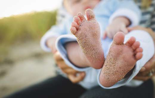 Infant baby foot with sand