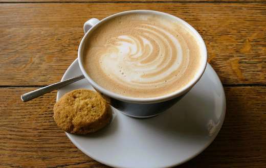 Cup of coffee and one biscuit