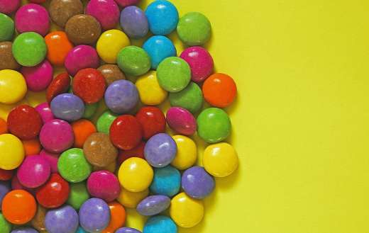 Colorful smarties in yellow background