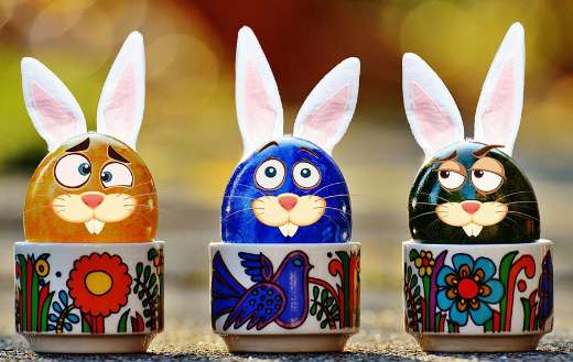 Colorful eggs paint bunny figure in cup