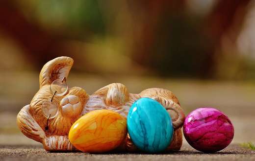 Multicolored eggs for easter and bunny statue