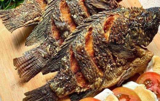 Fried tilapia with side eggs tomatoes