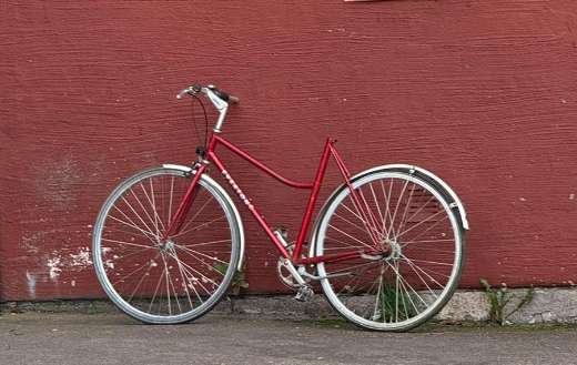 Red centurion womens bicycle leaning against red wall